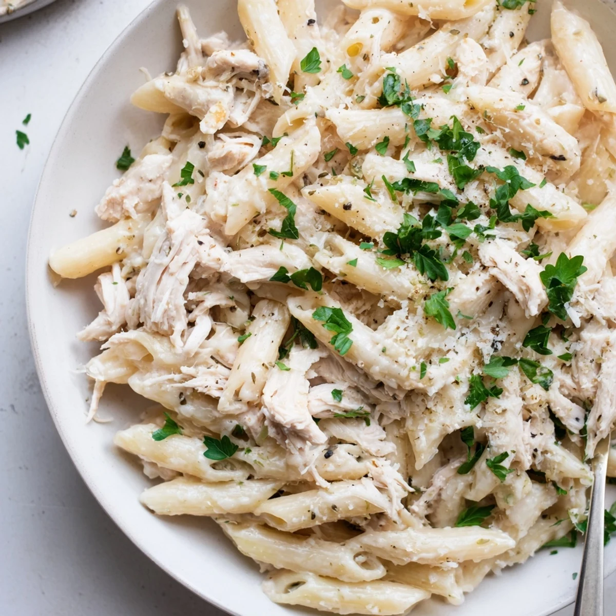 A close-up view of creamy Tinis Chicken Pasta with tender chicken, ready for a comforting meal.