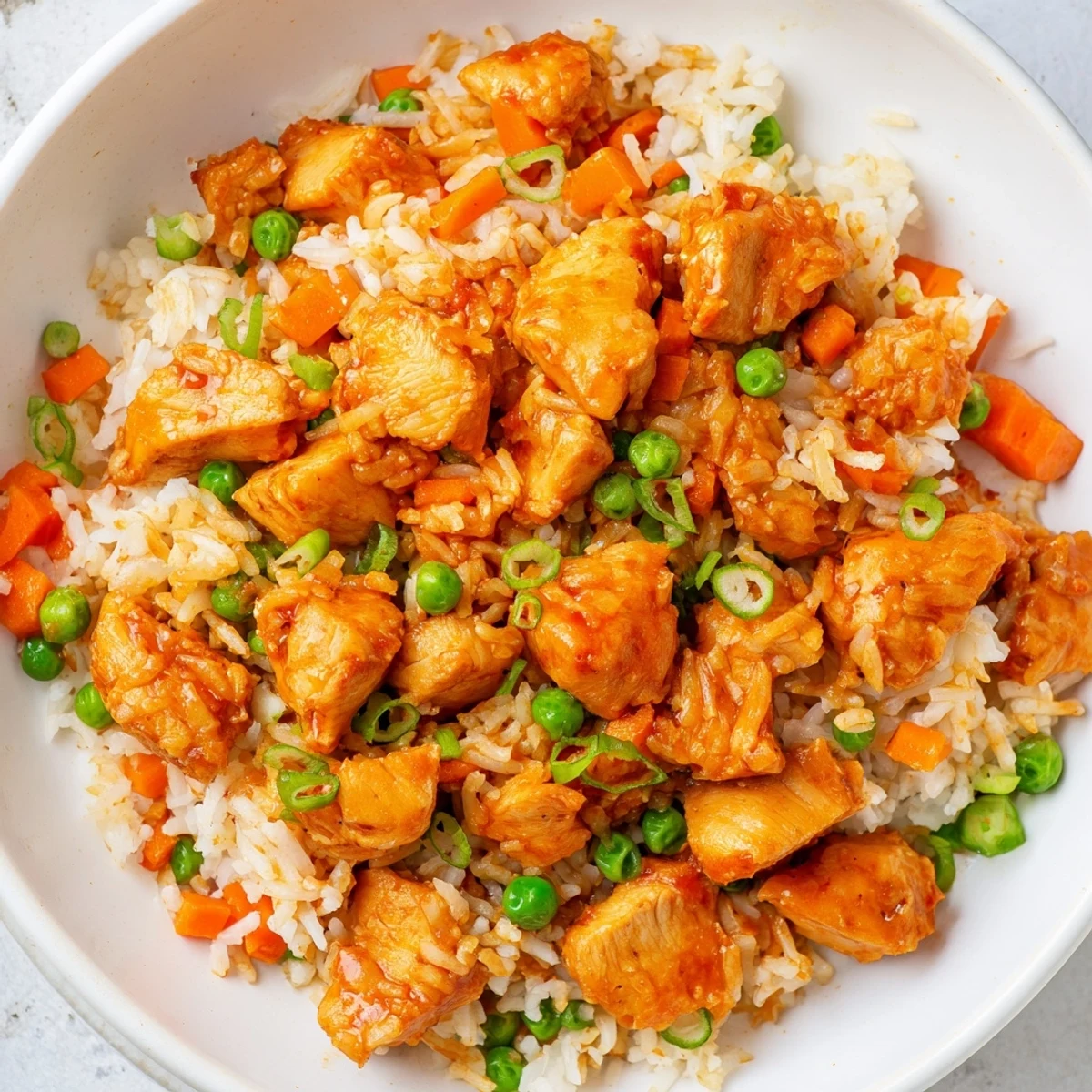 A close-up view of Butter Chicken Fried Rice garnished with fresh green onions.