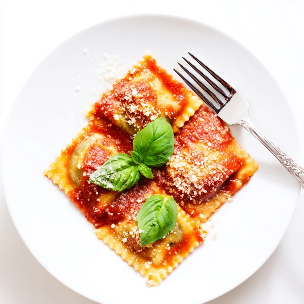 Close-up of golden Spinach Ricotta Ravioli, revealing creamy filling in rich tomato sauce on a rustic plate.