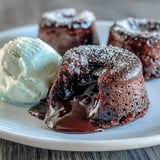 A close-up view of a Chocolate Lava Cake with Espresso being sliced open, revealing gooey, dark chocolate espresso filling.