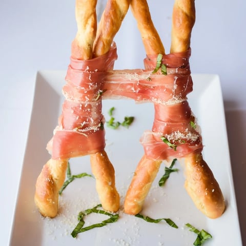 Golden Gate appetizer: Crunchy breadsticks bridge tender prosciutto, ready for easy party snacking in this dish.