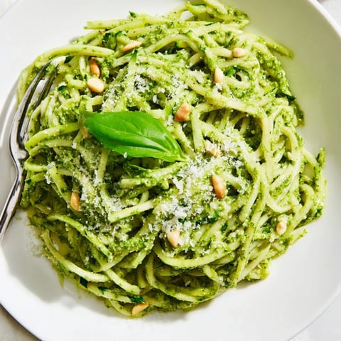 Freshly spiralized zucchini noodles tossed with homemade basil pesto, topped with extra Parmesan and red pepper flakes for a vibrant low-carb Italian-inspired dinner.