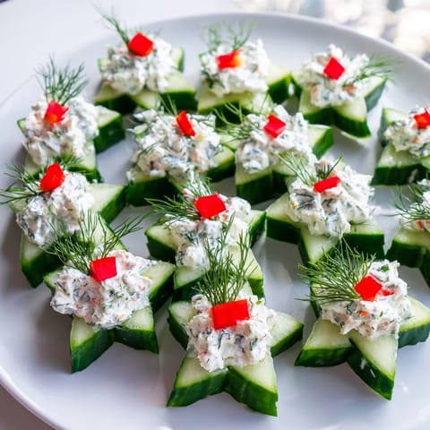 Bright appetizer of Cucumber and Dill Christmas Stars, garnished with red pepper and fresh dill.