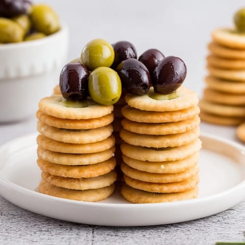 The Roman Colosseum Snack Platter displays olives as gladiators, ready to be enjoyed with cheese and tomatoes.