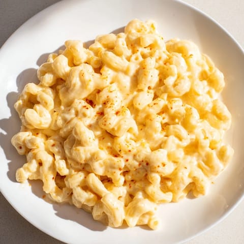 Enjoy a steaming bowl of Tini's Recession Mac: comforting elbow macaroni swimming in a rich, cheesy sauce.