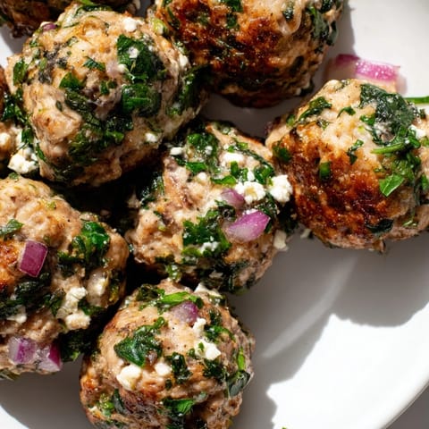 A platter of delicious spinach feta turkey meatballs, served hot with fresh parsley garnish.