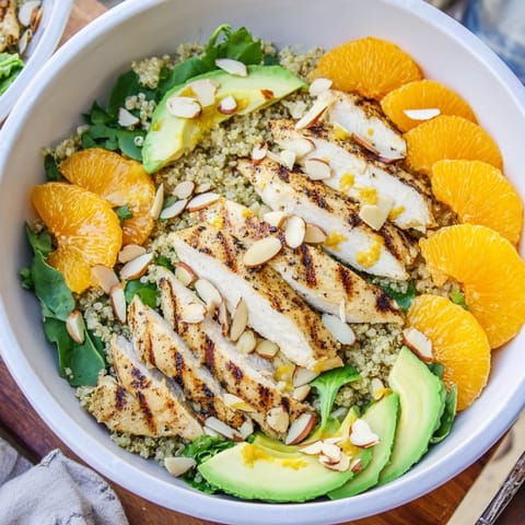 Freshly grilled herb chicken rests atop a bed of mixed greens and quinoa in this bright salad bowl.