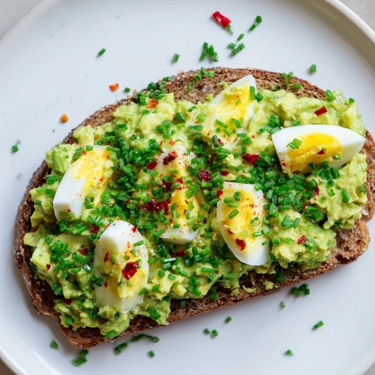 Smashed avocado and egg mixture, vibrant green, ready to spread on toasted whole grain for a quick Avocado Egg Smash.