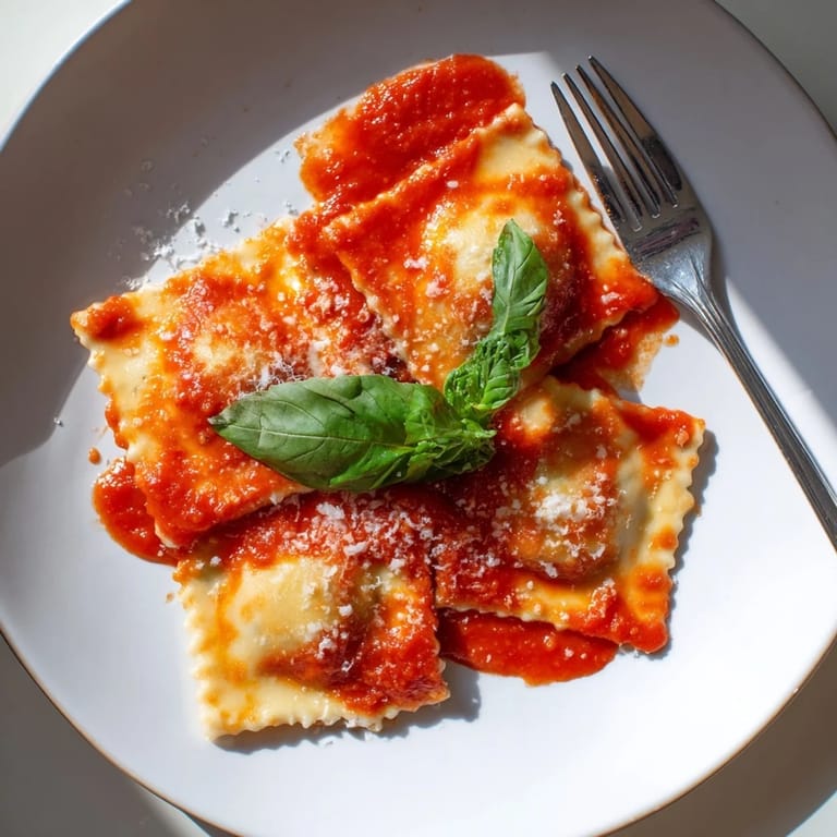 Steaming Spinach Ricotta Ravioli served on a dinner plate, paired with a glass of white wine for dinner.