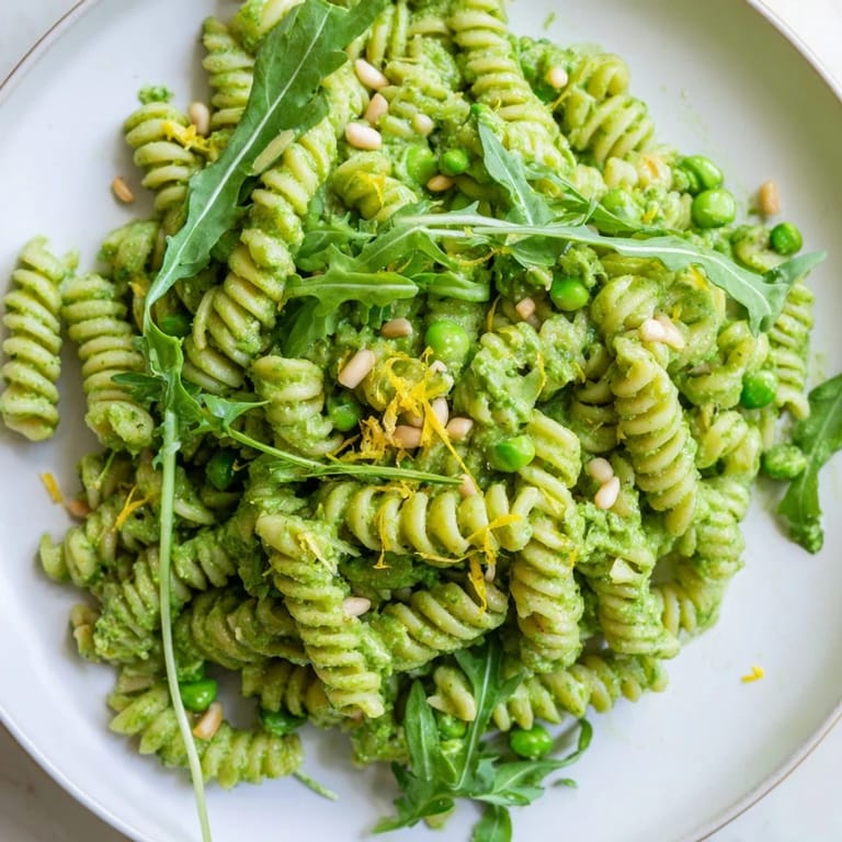 Fusilli pasta coated in homemade pesto, brightened with lemon zest and topped with crumbled feta.