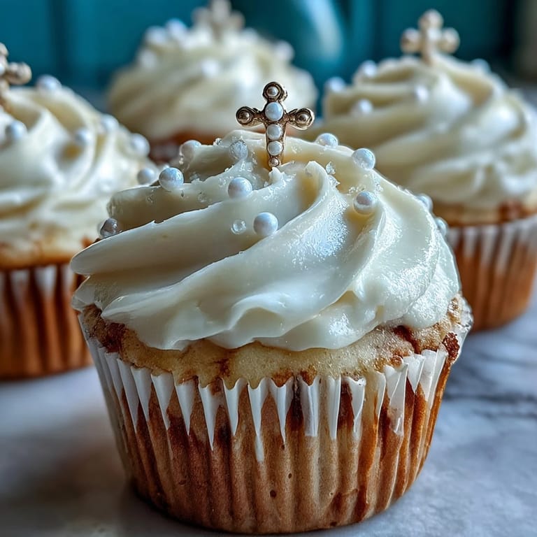 Soft vanilla mini cupcakes with buttercream swirls and handmade fondant rosary toppers, a beautiful First Communion dessert.
