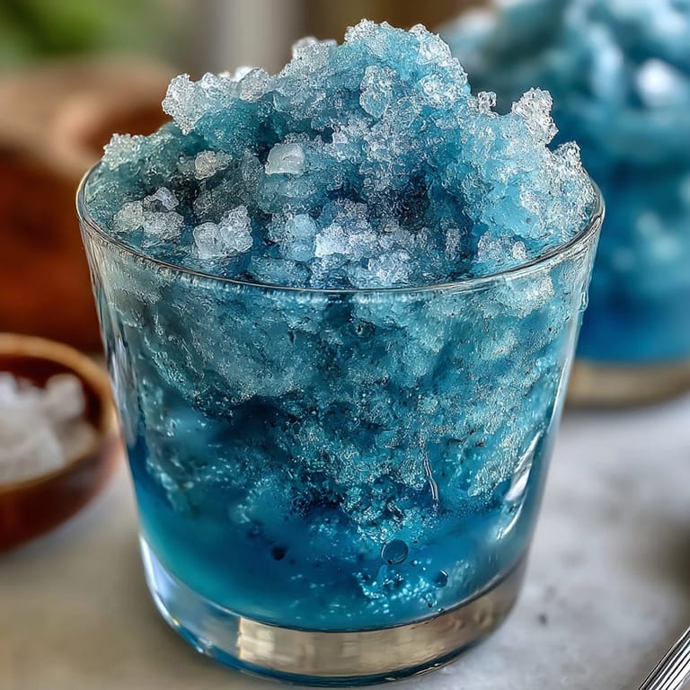 Cool, refreshing blue raspberry lemonade slushie with a frosty texture, ideal for parties and sunny afternoons.